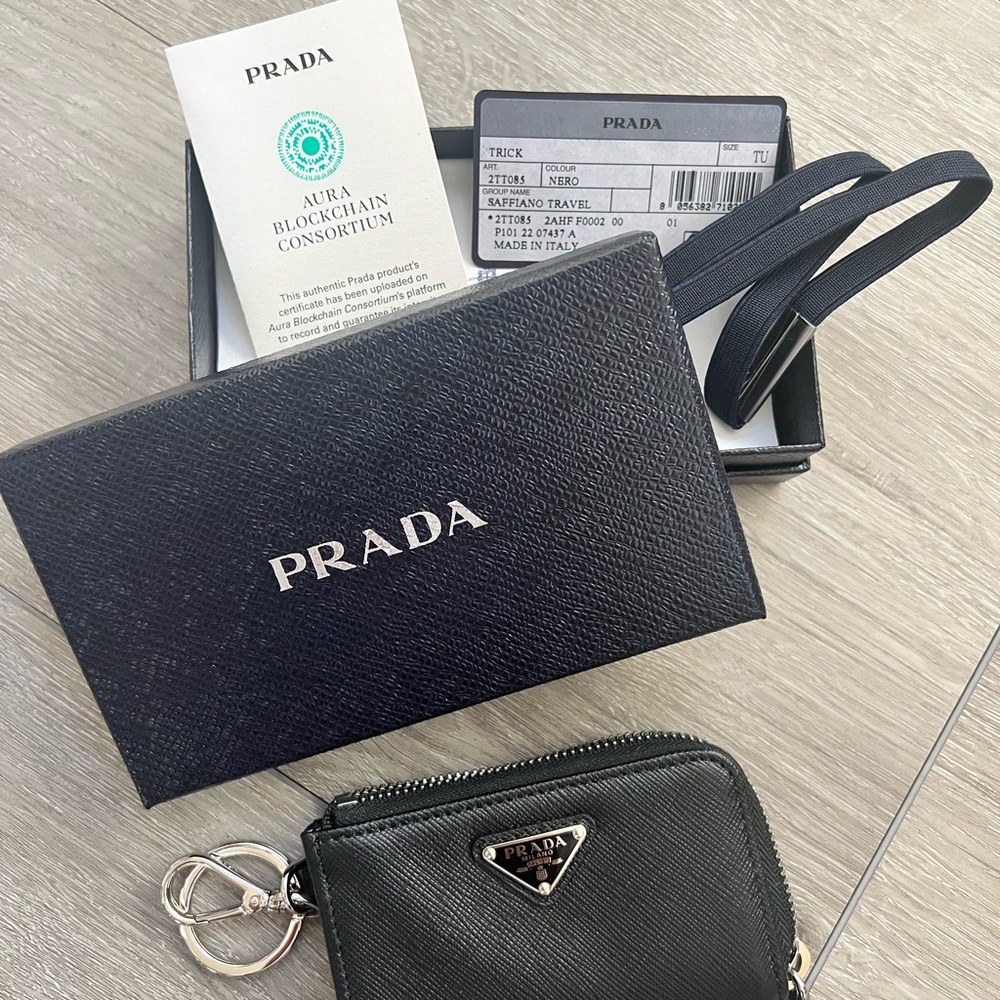 snap-hook and ring
Zipper closure
Enameled metal triangle logo
Two card slots